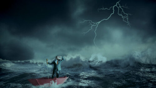 A man on a boat in the middle of the ocean with a storm around him.