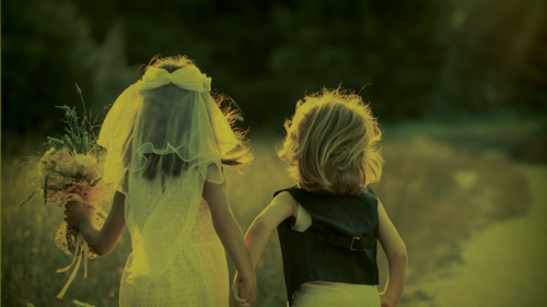 Children dressed as a bride and groom running away from the camera