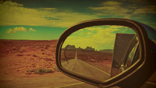 A car side mirror with a landscape