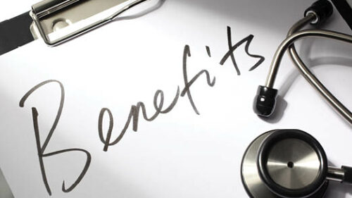 The word benefits scrawled across a clipboard next to medical equipment