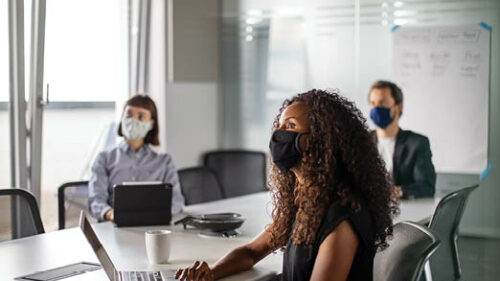 Office workers wearing face masks during a meeting