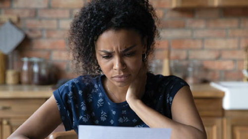 A woman looking confused at a piece of paper