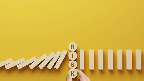A yellow background with wooden blocks and the word Risk.