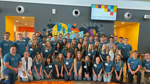 A large group of college students wearing Give.Fully. t-shirts in the Holmes Murphy headquarters.