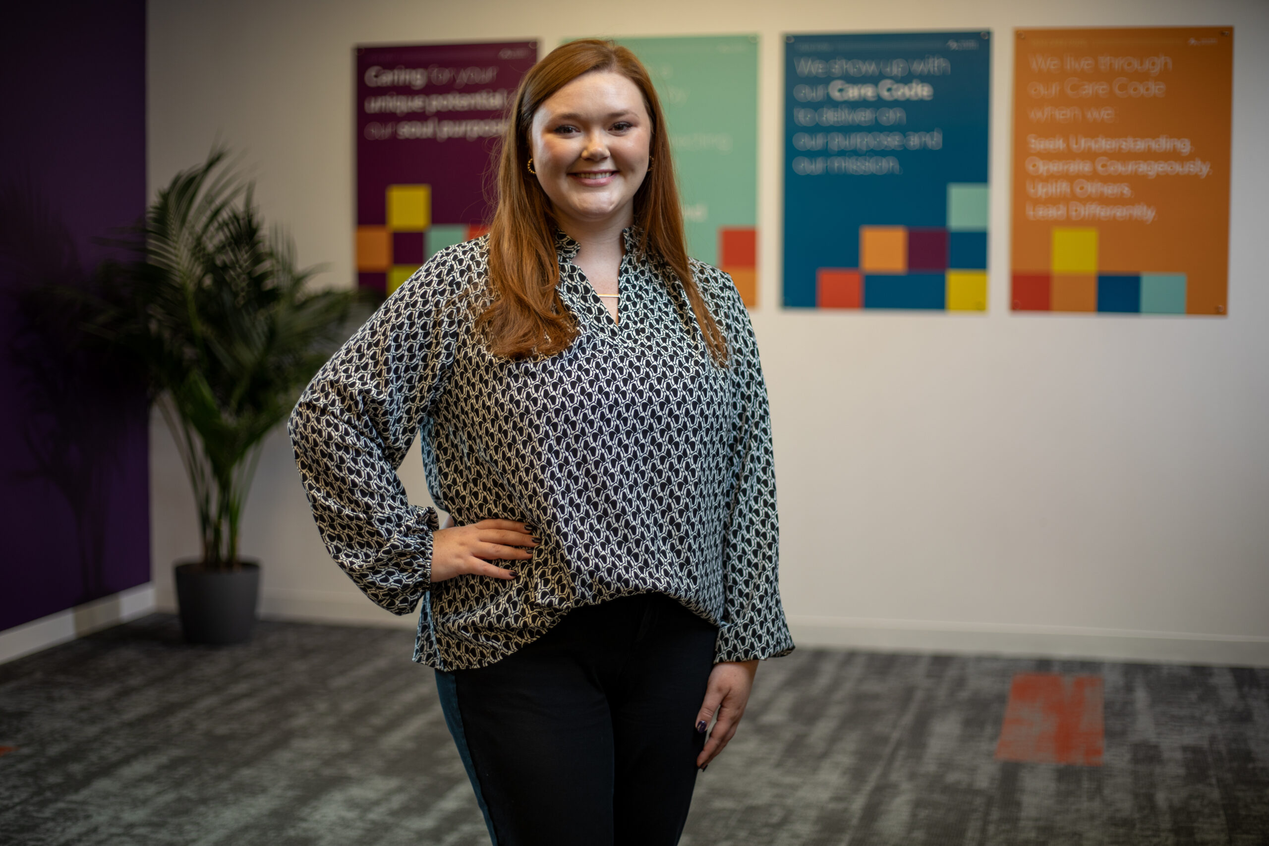 Abby Hickman in a black and white blouse standing in the Holmes Murphy office.