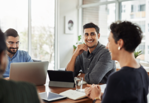 Happy employees sitting around a conference table