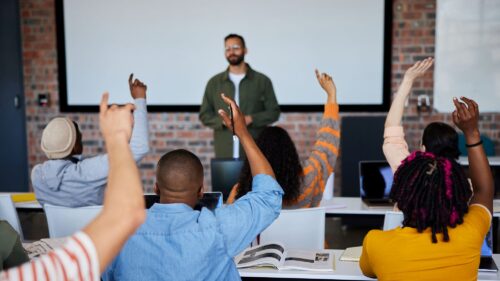 Diverse college students participating in class.