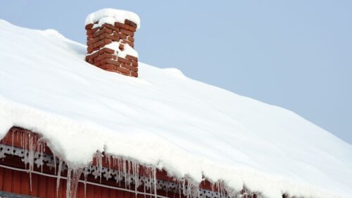 A snowy and icy roof on a fraternity or sorority house
